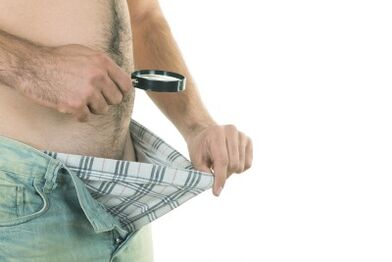 Un hombre mira su pene y quiere aumentar su tamaño.